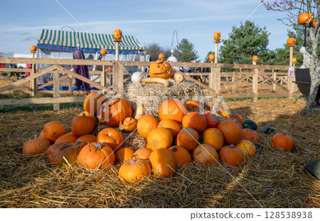 Pile of pumpkins and hay in festive Halloween setup Pile of pumpkins and hay in festive Halloween setup 128538938