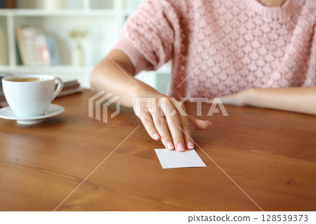 Woman hand giving you a business card Woman hand giving you a business card 128539373