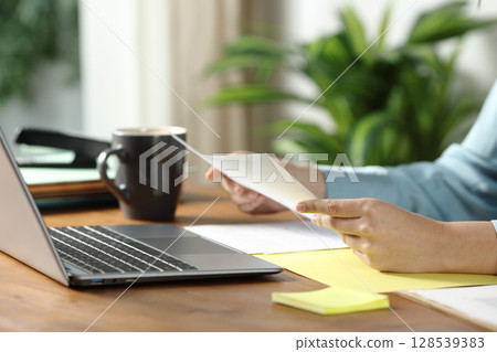 Woman hands holding document on wooden table 128539383