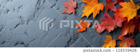Vibrant Autumn Leaves on Concrete Background 128539426