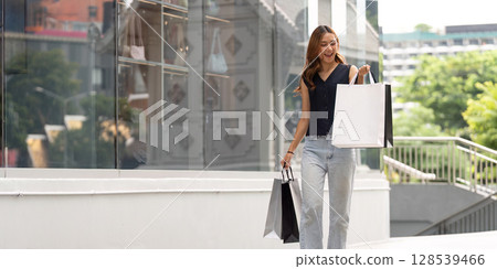 Black Friday Shopping. Happy woman carrying shopping bags outdoors. Black Friday Shopping. Happy woman carrying shopping bags outdoors. 128539466