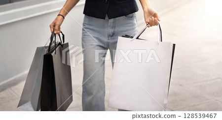 Black Friday Shopping. Woman holding shopping bags while walking. Black Friday Shopping. Woman holding shopping bags while walking. 128539467