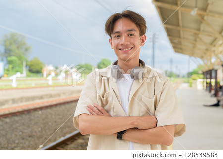 Young non binary tourist traveler in train station 128539583