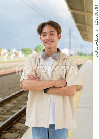 Young non binary tourist traveler in train station Young non binary tourist traveler in train station 128539584