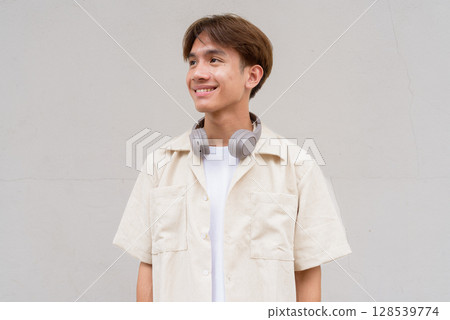 Non binary cute Asian young gay man thinking against studio background Non binary cute Asian young gay man thinking against studio background 128539774