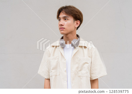 Non binary cute Asian young gay man thinking against studio background Non binary cute Asian young gay man thinking against studio background 128539775