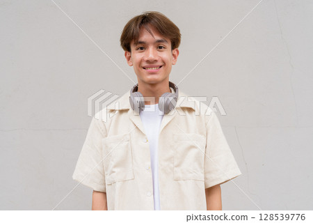 Non binary cute Asian young gay man portrait against studio background Non binary cute Asian young gay man portrait against studio background 128539776