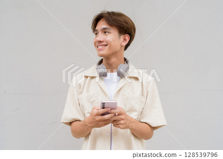 Non binary cute Asian young gay man using phone 128539796