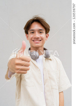 Non binary person giving thumbs up and smiling Non binary person giving thumbs up and smiling 128539797