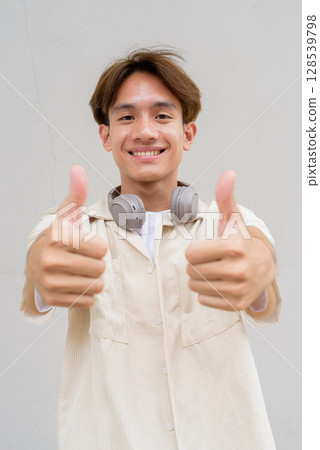 Non binary person giving thumbs up and smiling Non binary person giving thumbs up and smiling 128539798