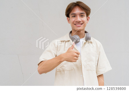 Non binary person giving thumbs up and smiling Non binary person giving thumbs up and smiling 128539800