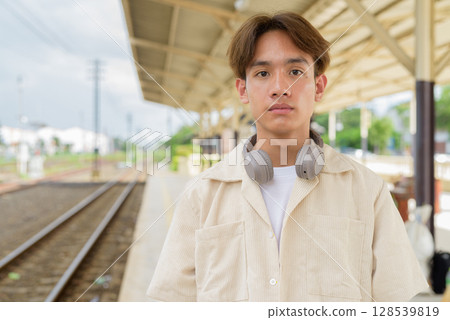 Young non binary tourist traveler in train station Young non binary tourist traveler in train station 128539819