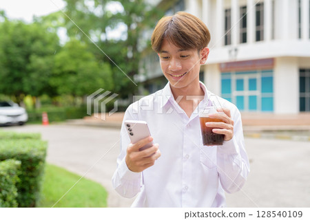 Non binary university student in college campus Non binary university student in college campus 128540109