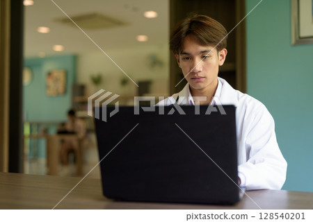 Doctor sitting and using laptop computer 128540201