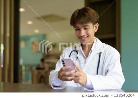 Doctor sitting and using phone while texting 128540204