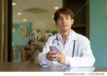 Doctor sitting and using phone while texting 128540208
