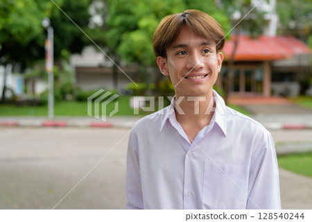 Non binary university student smiling in college campus Non binary university student smiling in college campus 128540244