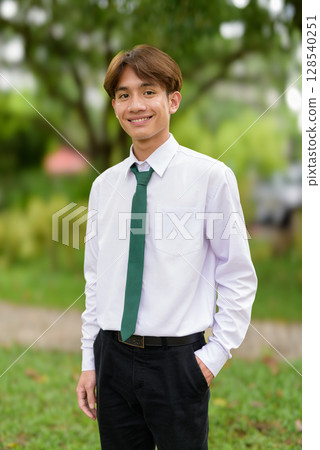 Non binary university student in college campus 128540251