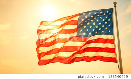American Flag Waving Proudly At Sunset On National Holiday. Concept of Patriotism, Independence Day, Freedom Celebration, Government Events, And Traditional Americana-Inspired Visual Identity American Flag Waving Proudly At Sunset On National Holiday. Concept of Patriotism, Independence Day, Freedom Celebration, Government Events, And Traditional Americana-Inspired Visual Identity 128540439