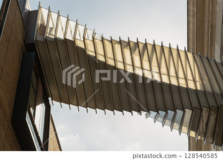 View from below of The futuristic modern of Twisted sky bridge connecting Royal opera house to Royal ballet school in Covent garden. View from below of The futuristic modern of Twisted sky bridge connecting Royal opera house to Royal ballet school in Covent garden. 128540585