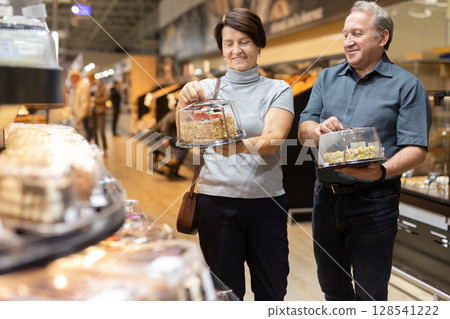 husband and wife choose cake in store for festive dinner 128541222