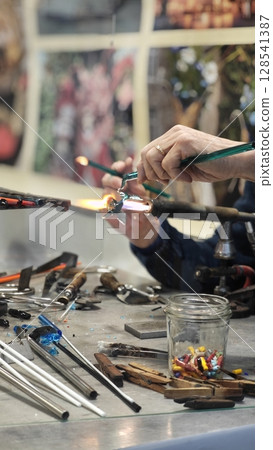 Crafting colorful glass art in a bustling workshop filled with tools and creativity 128541387