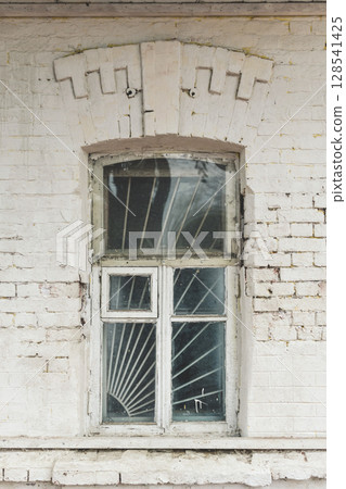 Old brick building with a glass window. Window with bars. old house 128541425
