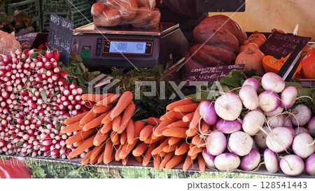 Vibrant market display of fresh vegetables with a variety of colors and textures showcasing local produce during a sunny afternoon Vibrant market display of fresh vegetables with a variety of colors and textures showcasing local produce during a sunny afternoon 128541443
