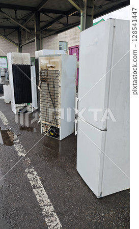 Discarded refrigerators awaiting recycling at an electronic waste facility on a rainy day in the city Discarded refrigerators awaiting recycling at an electronic waste facility on a rainy day in the city 128541447