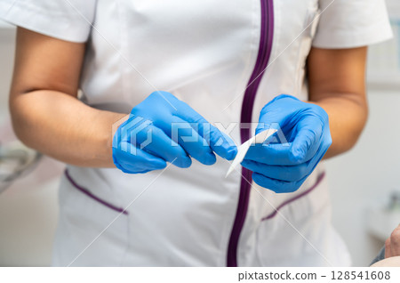Nurse preparing gauze to treat a patient Nurse preparing gauze to treat a patient 128541608