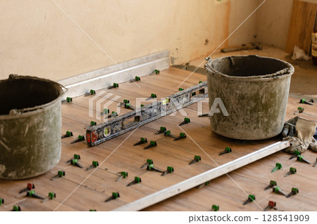 Working process, fixing tile on the floor. Working process, fixing tile on the floor. 128541909
