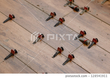 Tile Leveling System Components on The Floor. Closeup, selective focus. Tile Leveling System Components on The Floor. Closeup, selective focus. 128541911