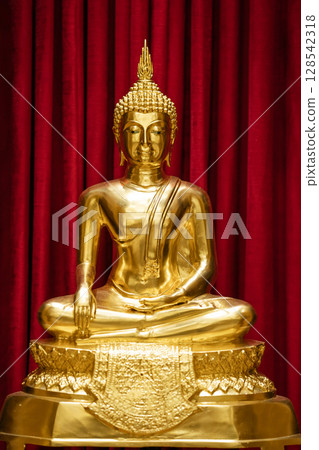 Brightness golden Buddha is sitting meditation in front of red scarlet curtain. Brightness golden Buddha is sitting meditation in front of red scarlet curtain. 128542318