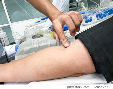 Blood platelet donation, a male nurse inserts a needle into donor arm to draw blood at a hospital. Blood platelet donation, a male nurse inserts a needle into donor arm to draw blood at a hospital. 128542339