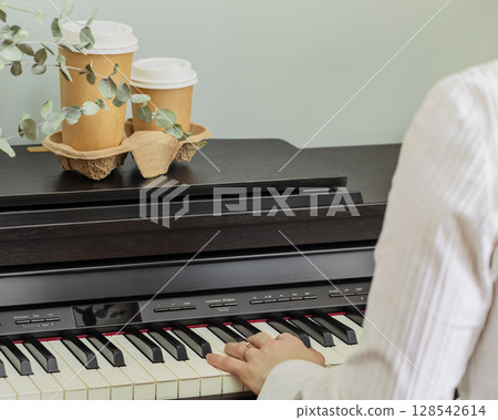 Spring romantic music composition with woman playing on piano with roses and two cups of coffee. Piano lessons, music education, hobby and relax at home concept. Coffee to go.Mothers day, womans day 128542614