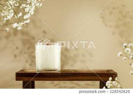Wooden empty podium with candle for beauty products on natural beige background with white flowers and shadows. Scene stage showcase for product, promotion sale or advertising. Front view Wooden empty podium with candle for beauty products on natural beige background with white flowers and shadows. Scene stage showcase for product, promotion sale or advertising. Front view 128542620