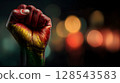 Hand is clenched into a fist, proudly raised up, Pan-African colors, June 19th Juneteenth day, Kwanzaa. Red, black, yellow and green colors. Africa Day. 128543583