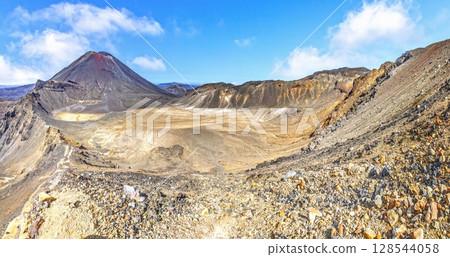 Dry volcanic crater under blue sky 128544058
