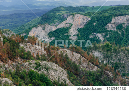 Rocky cliff mountains surrounded by lush forest and hills in Adygea Rocky cliff mountains surrounded by lush forest and hills in Adygea 128544288
