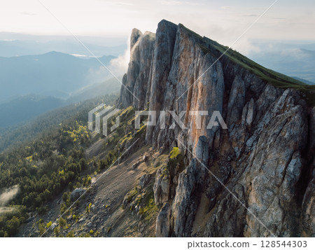Bolshoy Tkhach mountain in Caucasus with pre sunset or sunrise light, wall of tall rocks Bolshoy Tkhach mountain in Caucasus with pre sunset or sunrise light, wall of tall rocks 128544303