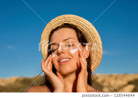 Beauty woman with suntan spf and skincare cosmetics model face portrait, woman applying lotion cream, sunscreen product. Skin and body care. A female smears moisturizing or suntan.Sun protection Beauty woman with suntan spf and skincare cosmetics model face portrait, woman applying lotion cream, sunscreen product. Skin and body care. A female smears moisturizing or suntan.Sun protection 128544644