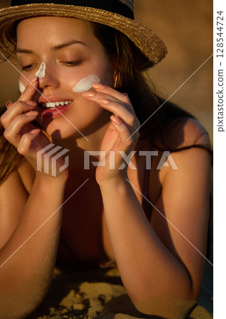Woman is applying a facial sunscreen product. Cream, moisturizer and facial woman in skincare, beauty or cosmetics. Face daily care routine. Woman is applying a facial sunscreen product. Cream, moisturizer and facial woman in skincare, beauty or cosmetics. Face daily care routine. 128544724