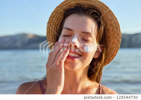 Beauty woman with suntan spf and skincare cosmetics model face portrait, woman applying lotion cream, sunscreen product. Skin and body care. A female smears moisturizing or suntan.Sun protection Beauty woman with suntan spf and skincare cosmetics model face portrait, woman applying lotion cream, sunscreen product. Skin and body care. A female smears moisturizing or suntan.Sun protection 128544730