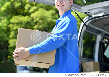 Asian male delivery staff carrying luggage 128544947