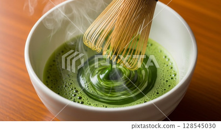 Preparing Matcha Green Tea with Traditional Bamboo Whisk in Ceramic Bowl 128545030