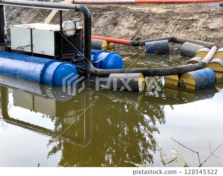 A water treatment system utilizes large blue and yellow containers while processing polluted water in a restoration effort at a water body 128545322