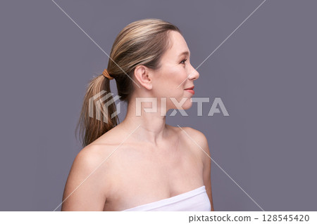 Profile of young caucasian female with blonde hair in neutral background wearing 128545420