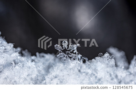 Macro snowflakes showing intricate winter details on dark background Macro snowflakes showing intricate winter details on dark background 128545675