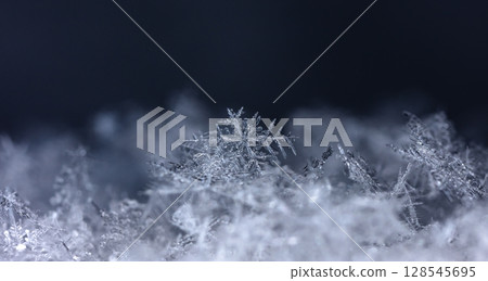 Macro snowflakes showing intricate winter details on dark background 128545695
