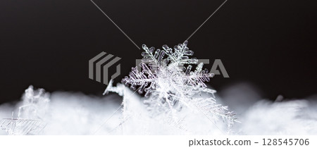 Macro snowflakes showing intricate winter details on dark background 128545706